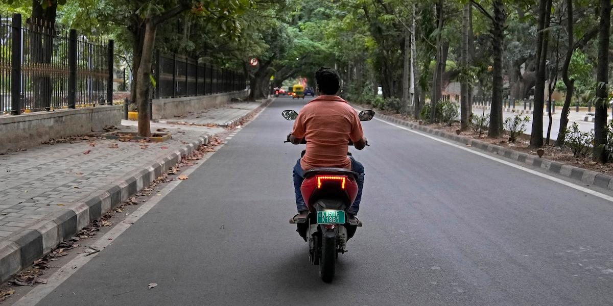 Man som kör skoter i Indien