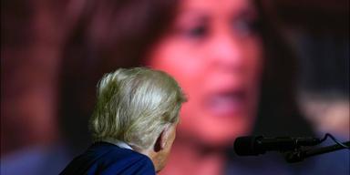 Donald Trump tittar på Kamala Harris på storbild