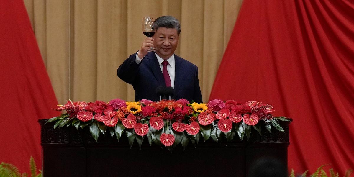 Bild på Kinas ledare Xi Jinping som skålar med ett glas rött vin under en partikonferens.