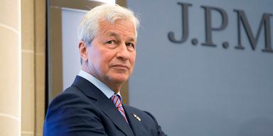 En halvbild på banken JP Morgans vd, Jamie Dimon. Han är fotograferad snett från sidan med kroppen vänd åt höger. Han bär marinblå kavaj och han står med armarna i kors.